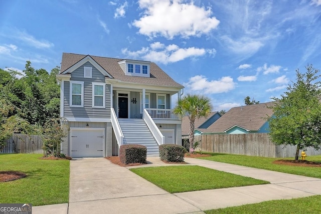 view of front of home with a garage, covered porch, and a front yard