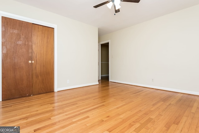 unfurnished bedroom featuring ceiling fan, light hardwood / wood-style floors, and a closet