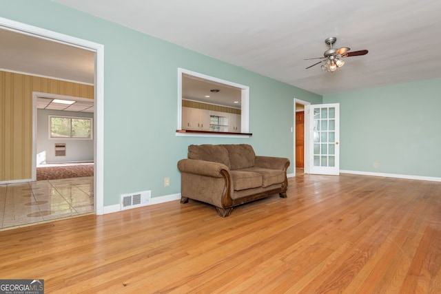 sitting room with french doors, light wood-type flooring, and ceiling fan