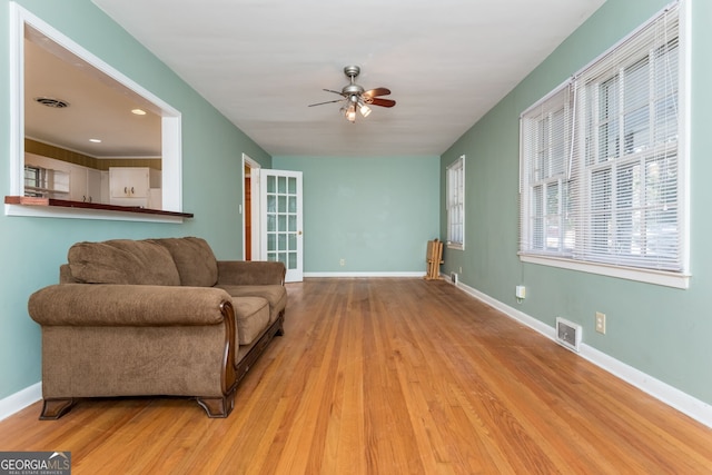 living room with ceiling fan and light hardwood / wood-style floors