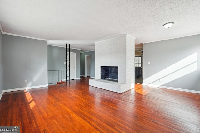 unfurnished living room with a fireplace, hardwood / wood-style floors, a textured ceiling, and ornamental molding