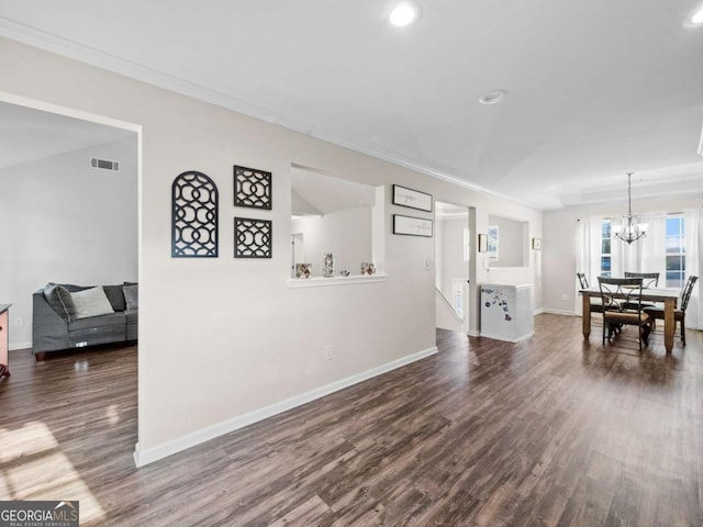 dining area with a notable chandelier, dark hardwood / wood-style floors, and ornamental molding