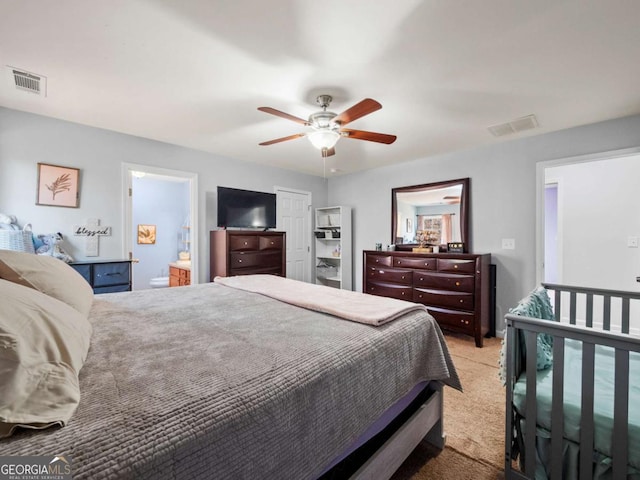 bedroom with light carpet, connected bathroom, and ceiling fan