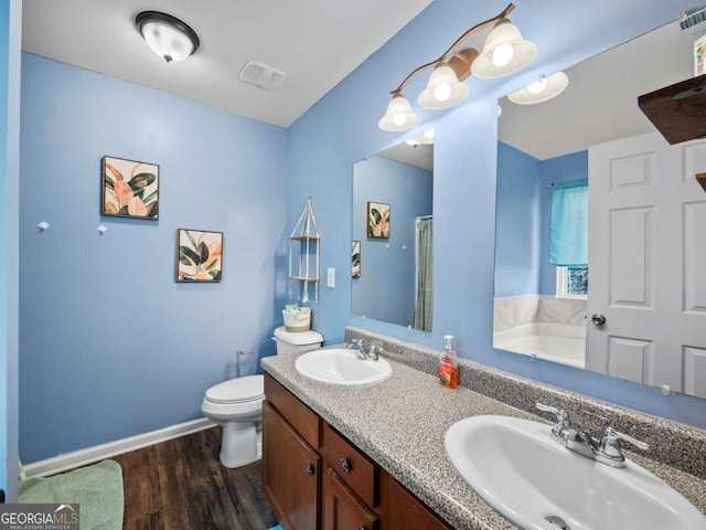 bathroom featuring hardwood / wood-style floors, vanity, a bathtub, and toilet