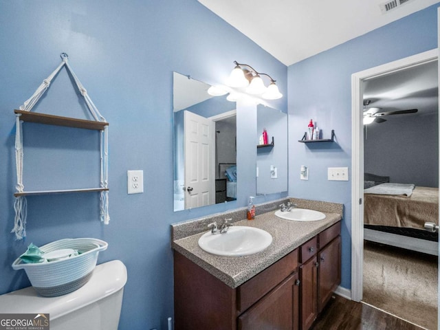 bathroom featuring hardwood / wood-style flooring, ceiling fan, toilet, and vanity