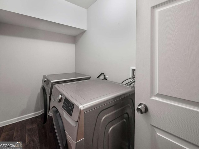 laundry room with separate washer and dryer and dark hardwood / wood-style flooring