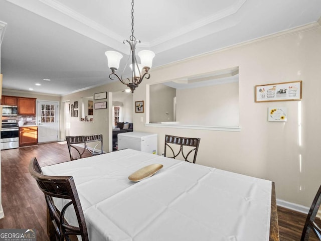 dining room with a chandelier, crown molding, and dark wood-type flooring