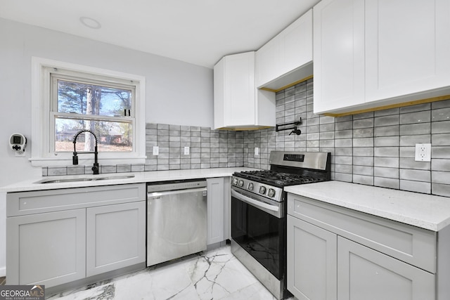 kitchen with white cabinetry, sink, stainless steel appliances, light stone counters, and backsplash