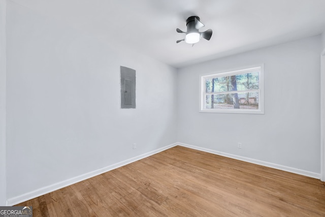 empty room featuring electric panel and light hardwood / wood-style floors