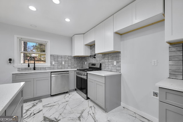 kitchen with decorative backsplash, stainless steel appliances, gray cabinetry, and sink