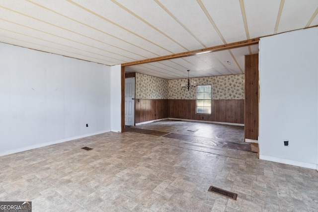 spare room featuring wood walls