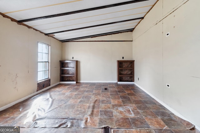 spare room with vaulted ceiling with beams