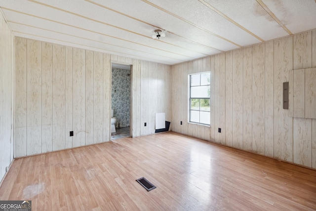 empty room featuring hardwood / wood-style floors and wood walls