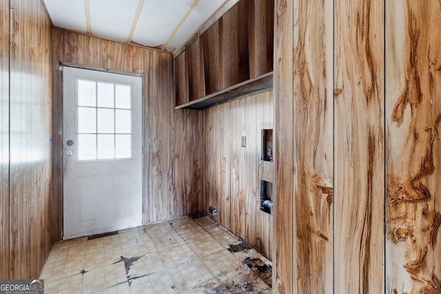 laundry area featuring wood walls