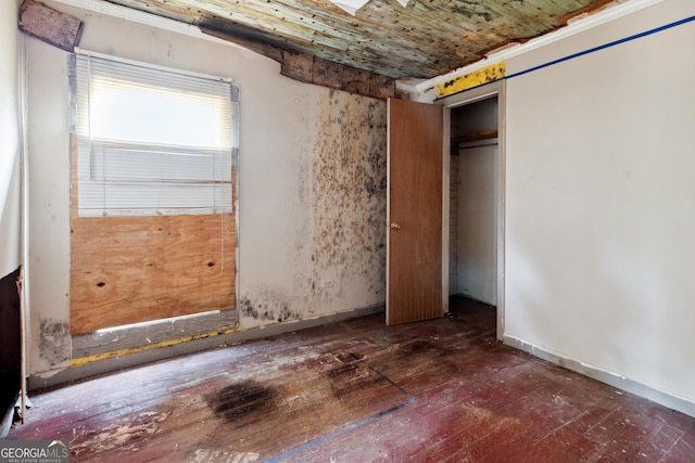 unfurnished bedroom with dark wood-type flooring and a closet