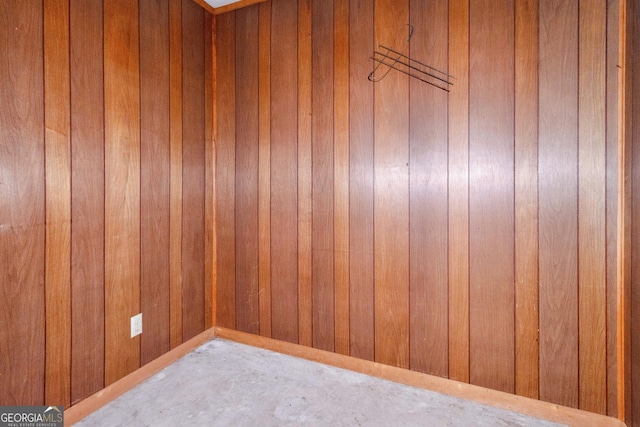 spare room featuring wood walls