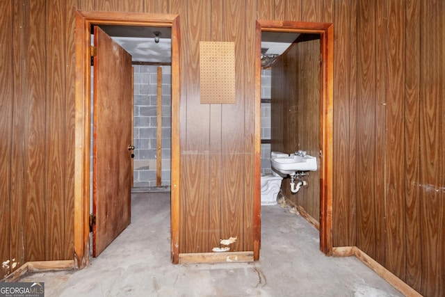 corridor featuring wooden walls