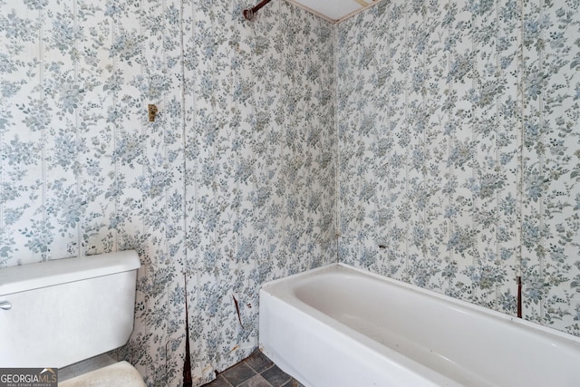 bathroom with a washtub and toilet