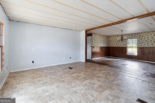 unfurnished room featuring wooden walls