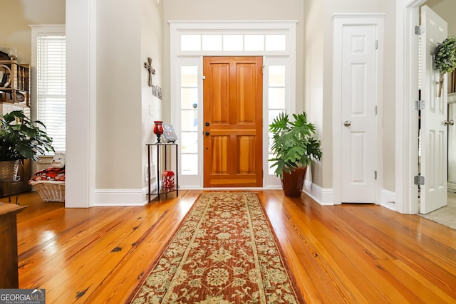 foyer with baseboards and wood finished floors