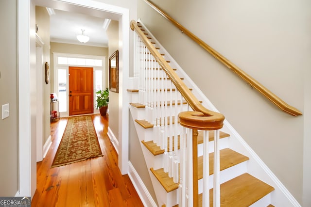 interior space featuring baseboards, ornamental molding, and wood finished floors