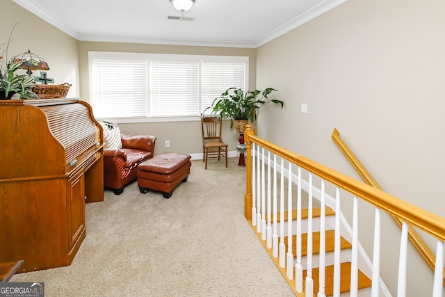 living area with an upstairs landing, visible vents, light colored carpet, and ornamental molding