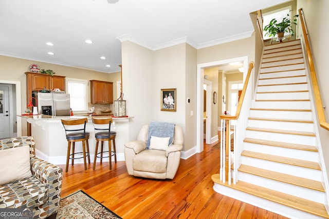 living area featuring light wood-type flooring, recessed lighting, stairway, and ornamental molding