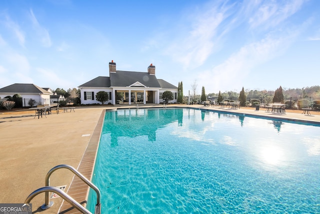 pool featuring fence and a patio