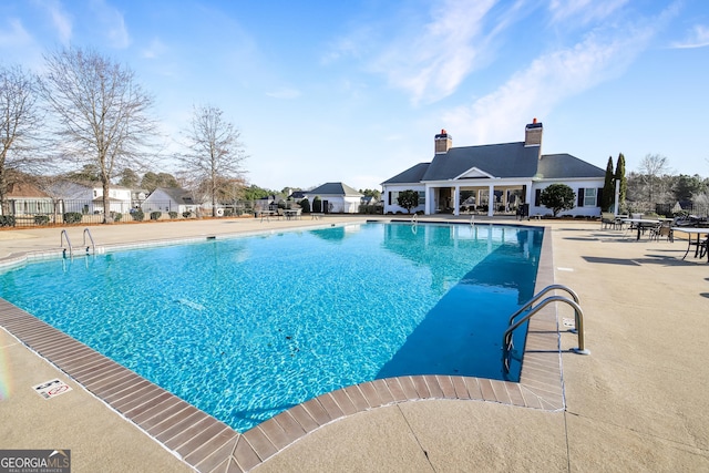 pool with a patio and fence