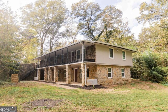 rear view of house featuring a sunroom, a patio area, and a yard