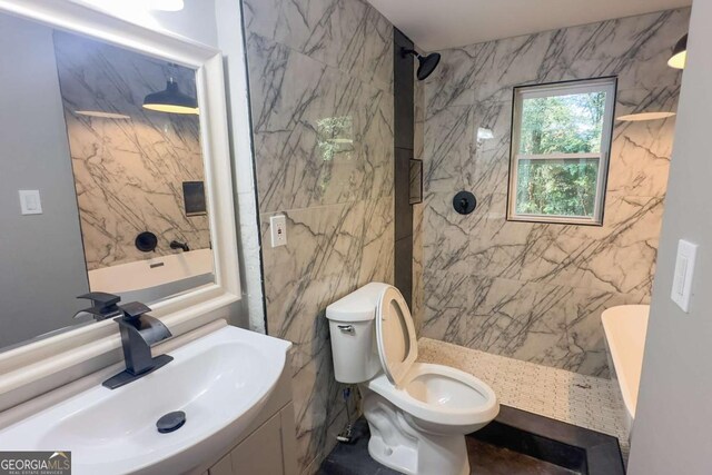 bathroom featuring tiled shower, toilet, tile walls, and sink