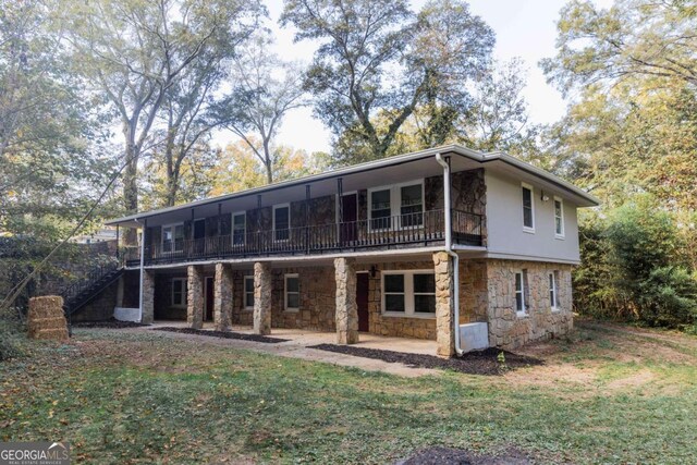 rear view of property featuring a yard and a patio