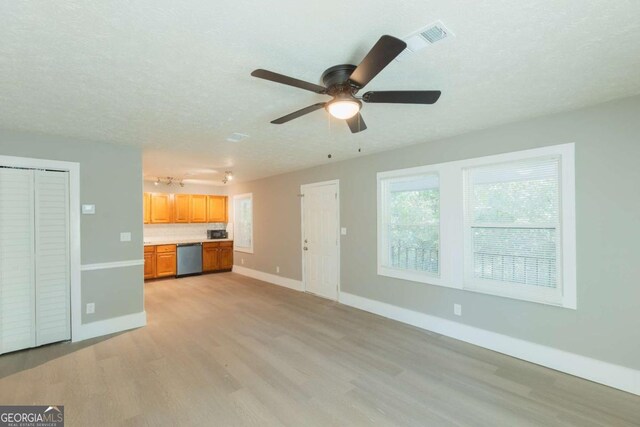 unfurnished living room with ceiling fan, light hardwood / wood-style floors, built in desk, and a textured ceiling