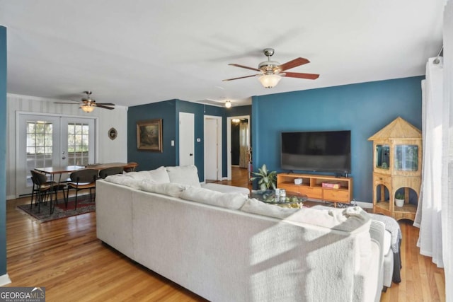 living room featuring ceiling fan, french doors, and light wood-type flooring