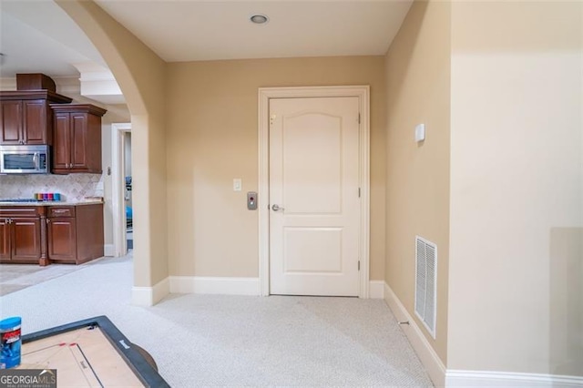 kitchen featuring decorative backsplash and light colored carpet