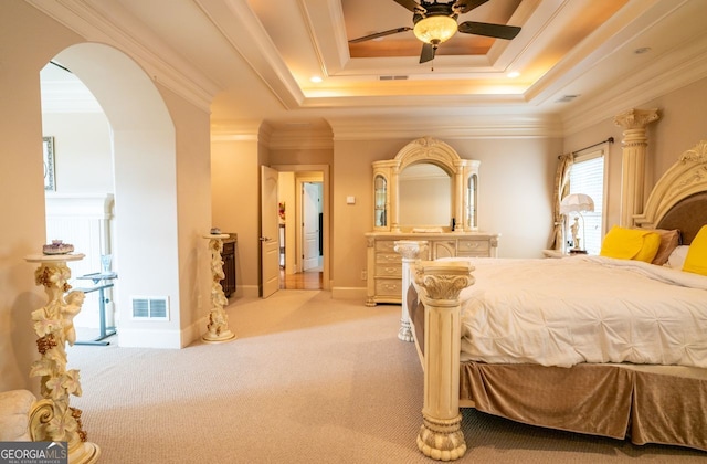 carpeted bedroom featuring ceiling fan, ornamental molding, and a tray ceiling