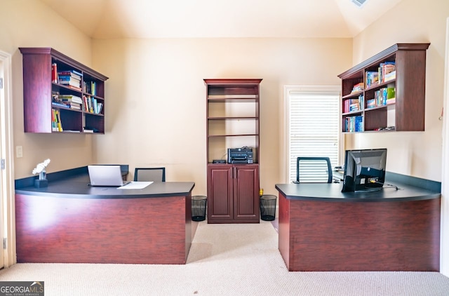 carpeted home office featuring built in desk and vaulted ceiling