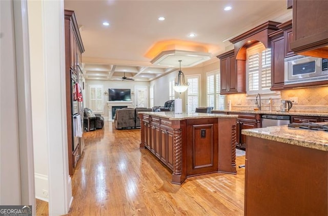 kitchen with a center island, light hardwood / wood-style floors, hanging light fixtures, and ceiling fan