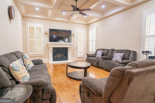 living room with beamed ceiling, light hardwood / wood-style flooring, ceiling fan, and coffered ceiling