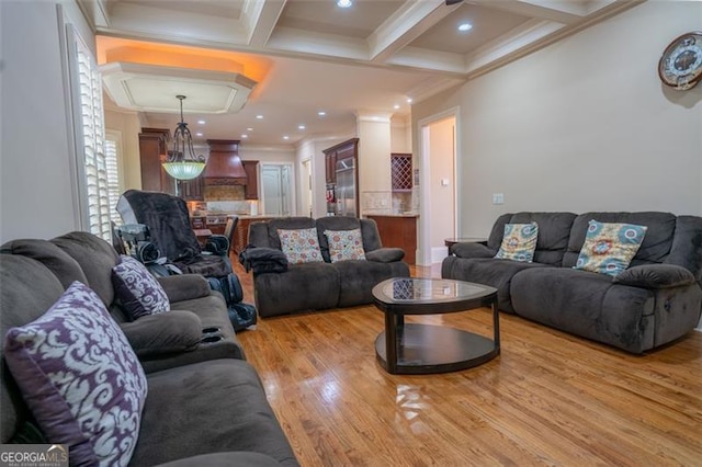 living room with beamed ceiling, light wood-type flooring, ornamental molding, and coffered ceiling