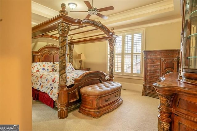 carpeted bedroom featuring a tray ceiling, ceiling fan, and crown molding