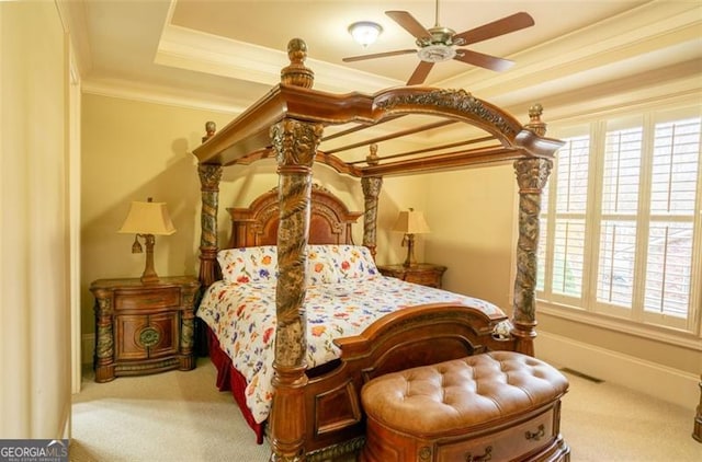 carpeted bedroom with a raised ceiling, ceiling fan, and crown molding