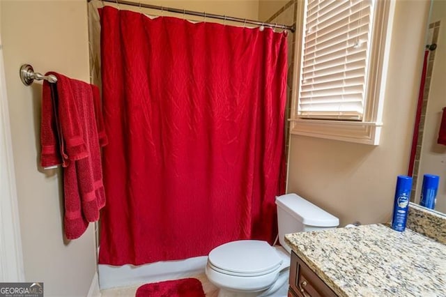 bathroom featuring curtained shower, vanity, and toilet