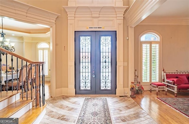 foyer featuring french doors, light wood-type flooring, and a healthy amount of sunlight