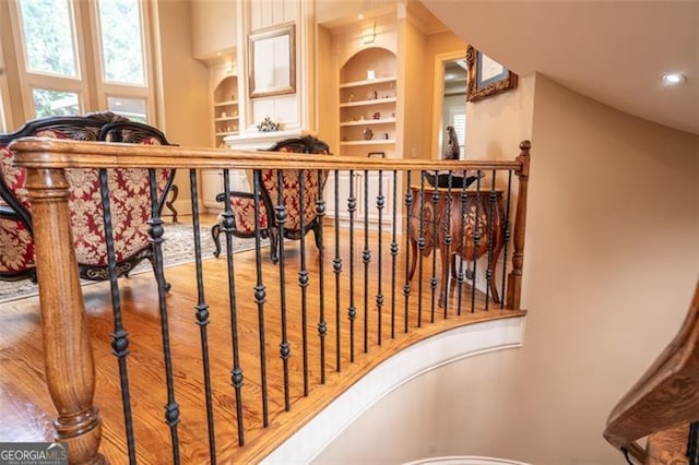 stairway with built in features and hardwood / wood-style flooring