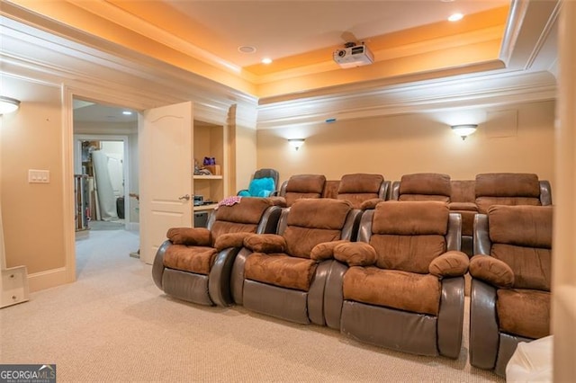 home theater room with a raised ceiling, crown molding, and light carpet