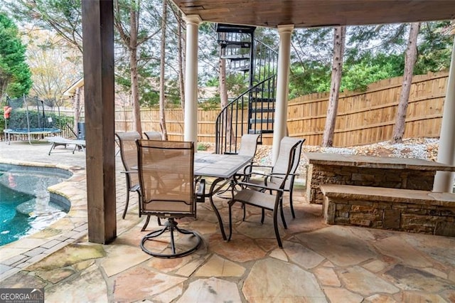 view of patio / terrace with a trampoline and a fenced in pool