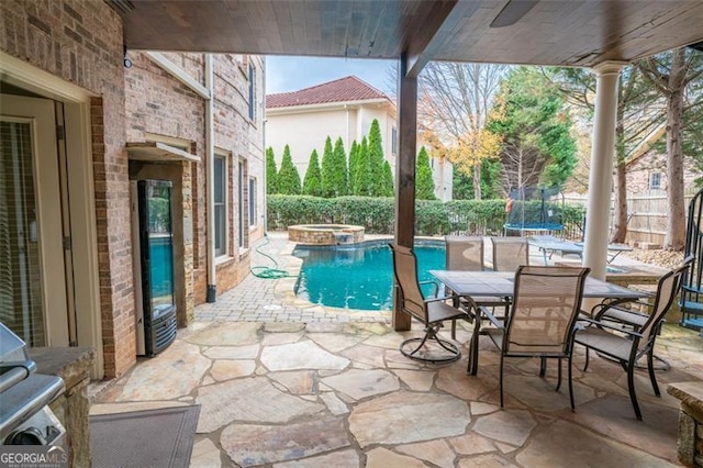 view of swimming pool with a trampoline, an in ground hot tub, and a patio