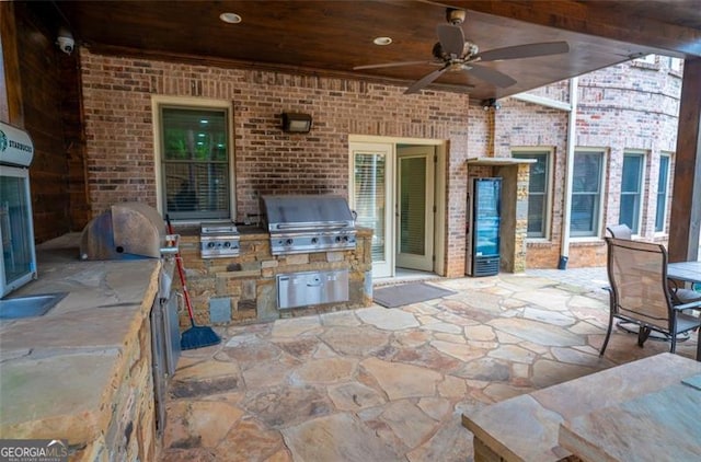 view of patio / terrace featuring ceiling fan, area for grilling, and exterior kitchen