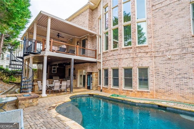 view of pool featuring ceiling fan, a patio, and an outdoor fire pit